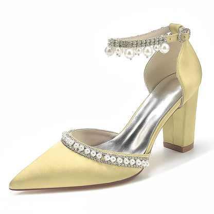 Beige high-heeled shoe with pearl and crystal embellishments on a white background