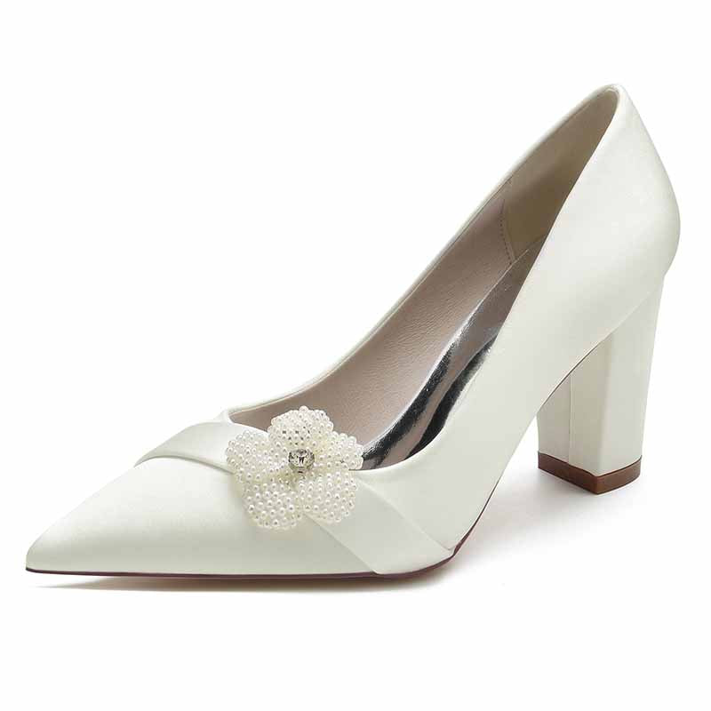 Elegant chunky heel bridal pumps in white with a floral embellishment for a stylish wedding look