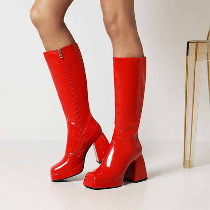 Red women's knee high boots with chunky heel featuring a sleek shiny finish and side zipper