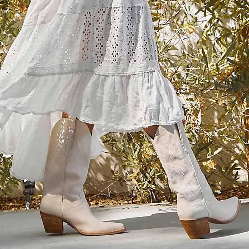 White embroidered cowgirl boots wedding paired with a flowing white dress for a stylish bridal look