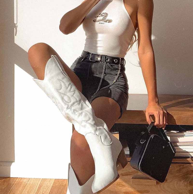 Embroidered square heel cowboy boots in white, styled with a crop top and denim skirt