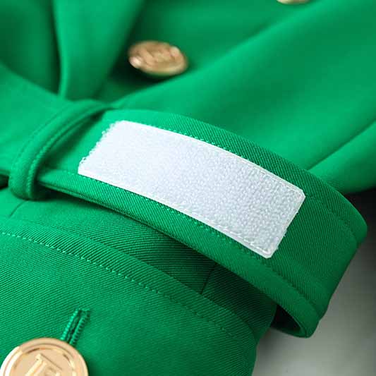 Close-up of an emerald green blazer for women showing gold buttons and sleeve detail