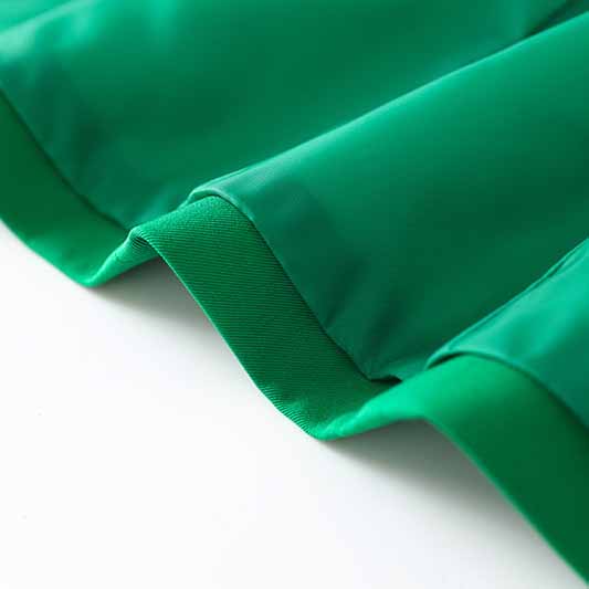 Close-up of emerald green blazer for women showcasing the smooth fabric and vibrant color