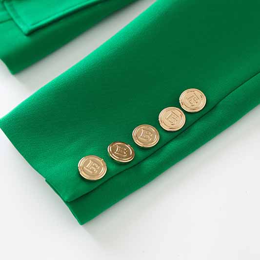 Detail of emerald green blazer for women featuring gold buttons on the cuffs