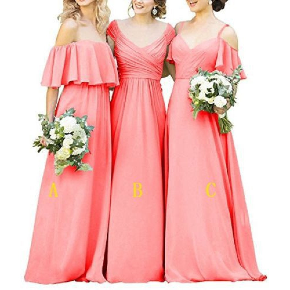 Three women in long chiffon bridesmaid dresses holding bouquets in coral color.