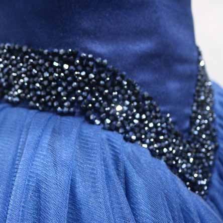 Close-up of an off the shoulder ball gown prom dress with detailed beaded embellishments in navy blue