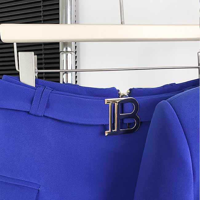 Close-up of a one-button bell-bottom suit for women featuring a stylish blue fabric and a decorative buckle