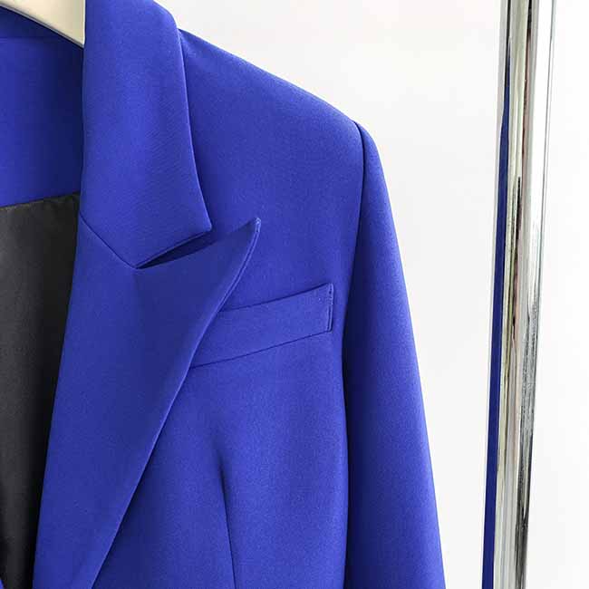 Elegant blue one-button bell-bottom suit for women displayed on a hanger, showcasing its tailored design