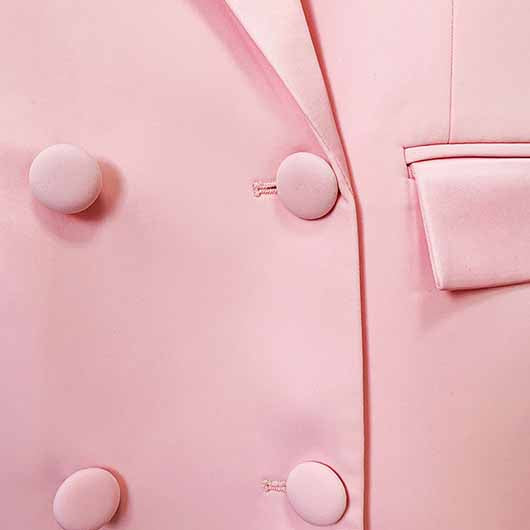 Close-up of a pink blazer pantsuit for women featuring stylish buttons and a tailored design