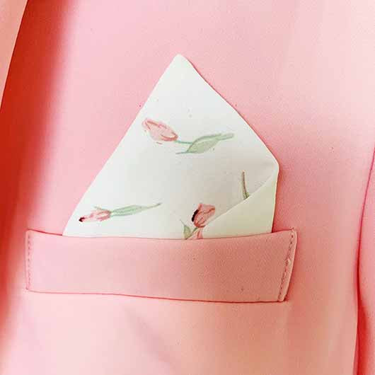 Close-up of a pink blazer pantsuit for women featuring a floral pocket square for a stylish look