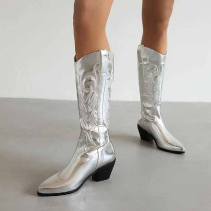 Shiny silver pointed toe western knee high boots with decorative stitching and a stylish heel