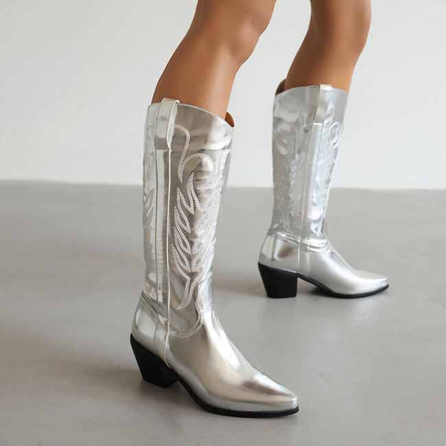 Shiny silver pointed toe western knee high boots with decorative stitching for a stylish cowgirl look