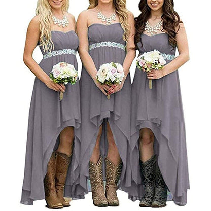 Three bridesmaids in strapless country wedding dress with lace trim and cowboy boots holding bouquets