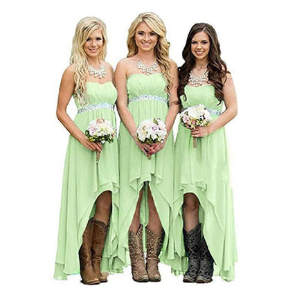 Three bridesmaids wearing strapless country wedding dress in light green with cowboy boots and floral bouquets