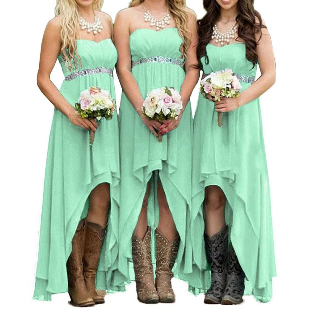 Three bridesmaids in mint strapless country wedding dress holding bouquets, wearing cowboy boots