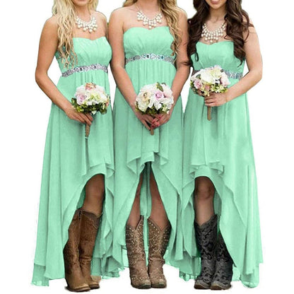 Three bridesmaids in mint strapless country wedding dress holding bouquets, wearing cowboy boots