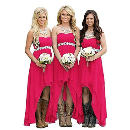 Three women in pink strapless country wedding dresses with floral bouquets and cowboy boots