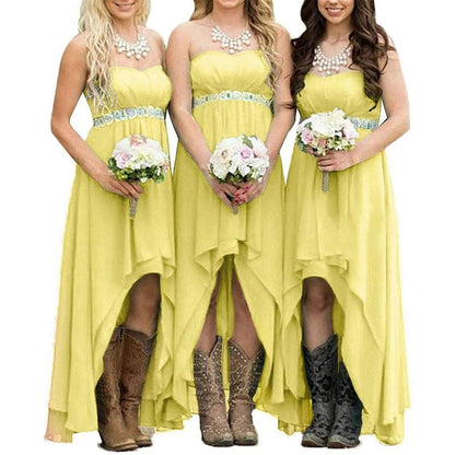 Three bridesmaids in strapless country wedding dress with high-low hem and cowboy boots holding bouquets