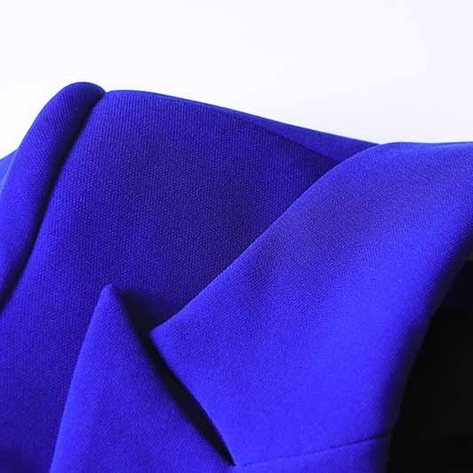 Close-up of a vibrant blue one button blazer and flare pants set showcasing fine tailoring and fabric details