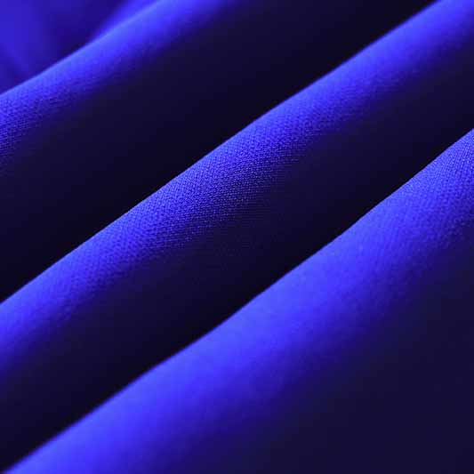 Vibrant fabric texture of a one button blazer and flare pants set in rich purple color