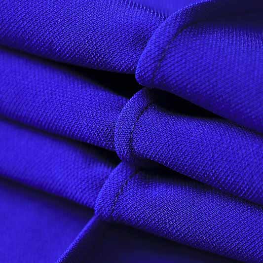 Close-up of vibrant fabric texture showcasing the one button blazer and flare pants set in deep purple