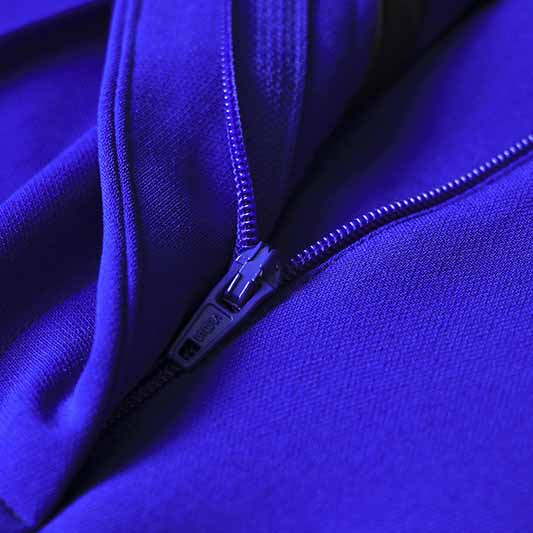 Close-up of a one button blazer and flare pants set in vibrant purple fabric with a zipper detail