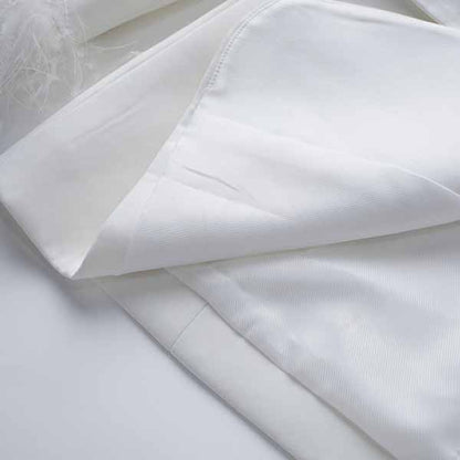 Close-up of Tucomosi women's wedding suit with feathers in elegant white fabric detail