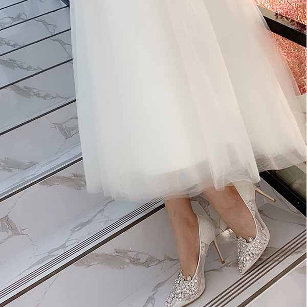 Elegant white rhinestone bridal wedding shoes with a high heel, perfect for a glamorous wedding day.