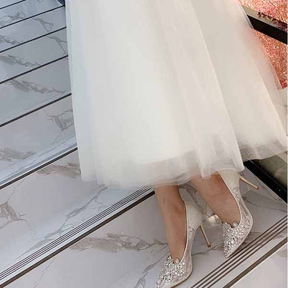 Elegant white rhinestone bridal wedding shoes with a high heel, perfect for a glamorous wedding day.