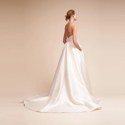 Elegant white slip wedding dress with a flowing train and simple back design