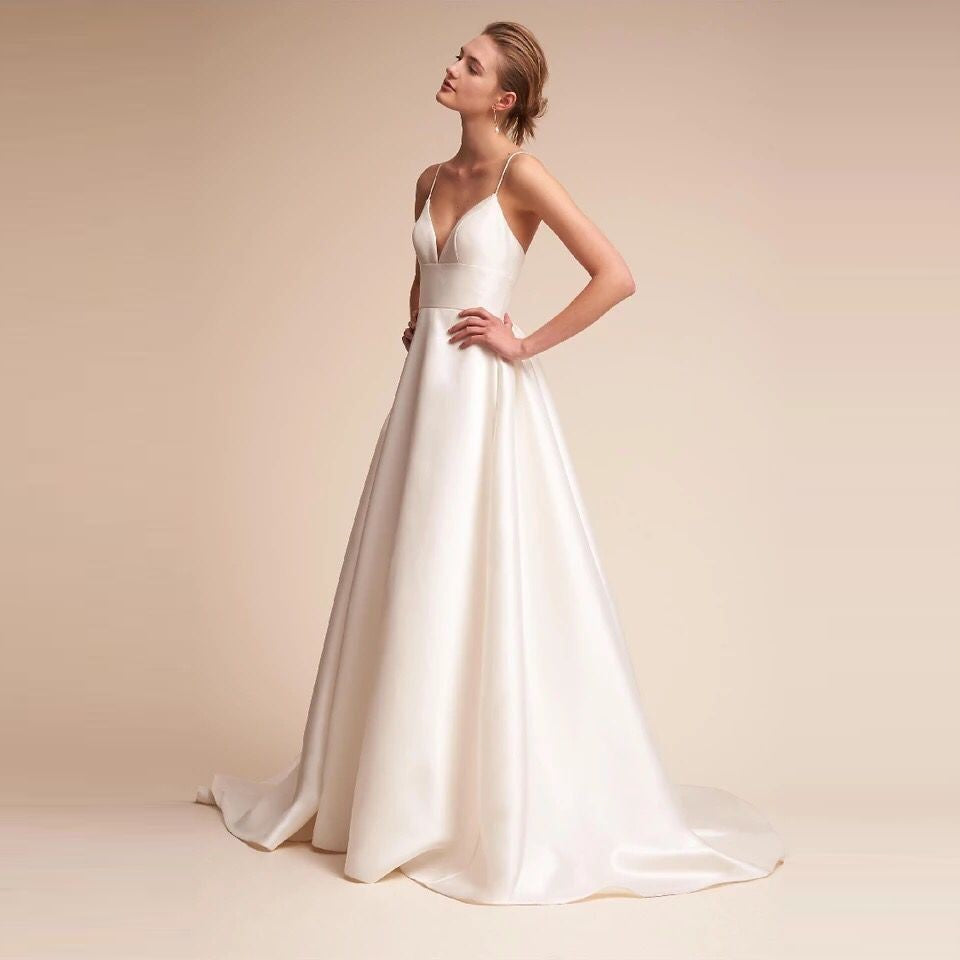 Elegant white slip wedding dress with a flattering V-neck and flowing skirt design for brides