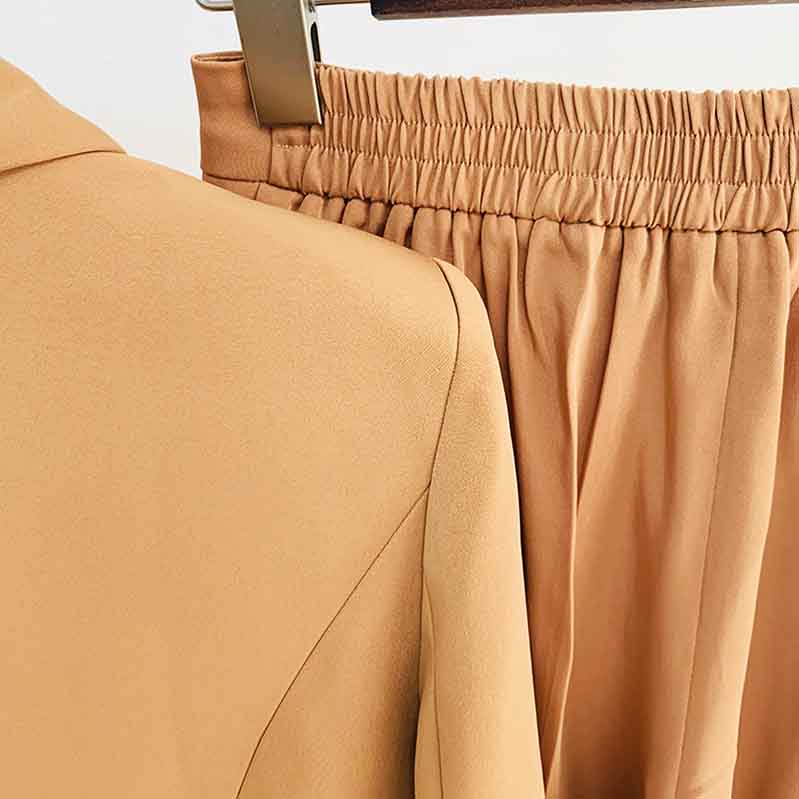 Close-up of women's camel pantsuit for work featuring soft fabric and elastic waistband for comfort