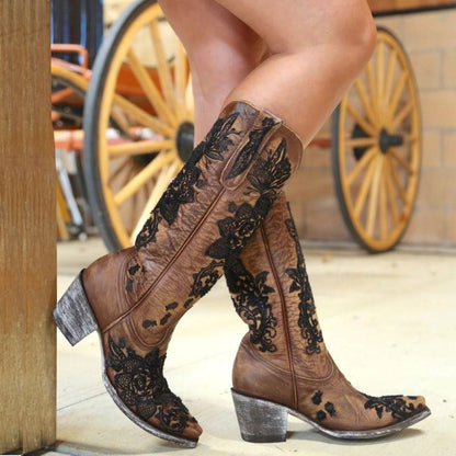 Women's embroidered cowboy boots in brown with intricate black floral designs and stylish stacked heels