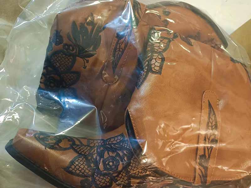 Women's embroidered cowboy boots in a clear bag showcasing intricate floral designs