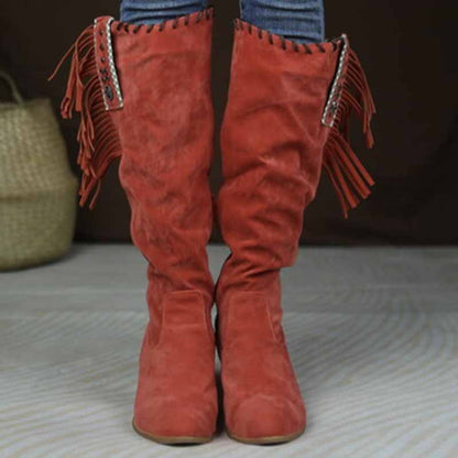 Stylish women's knee high cowgirl boots in red with fringe and decorative hardware for a trendy look