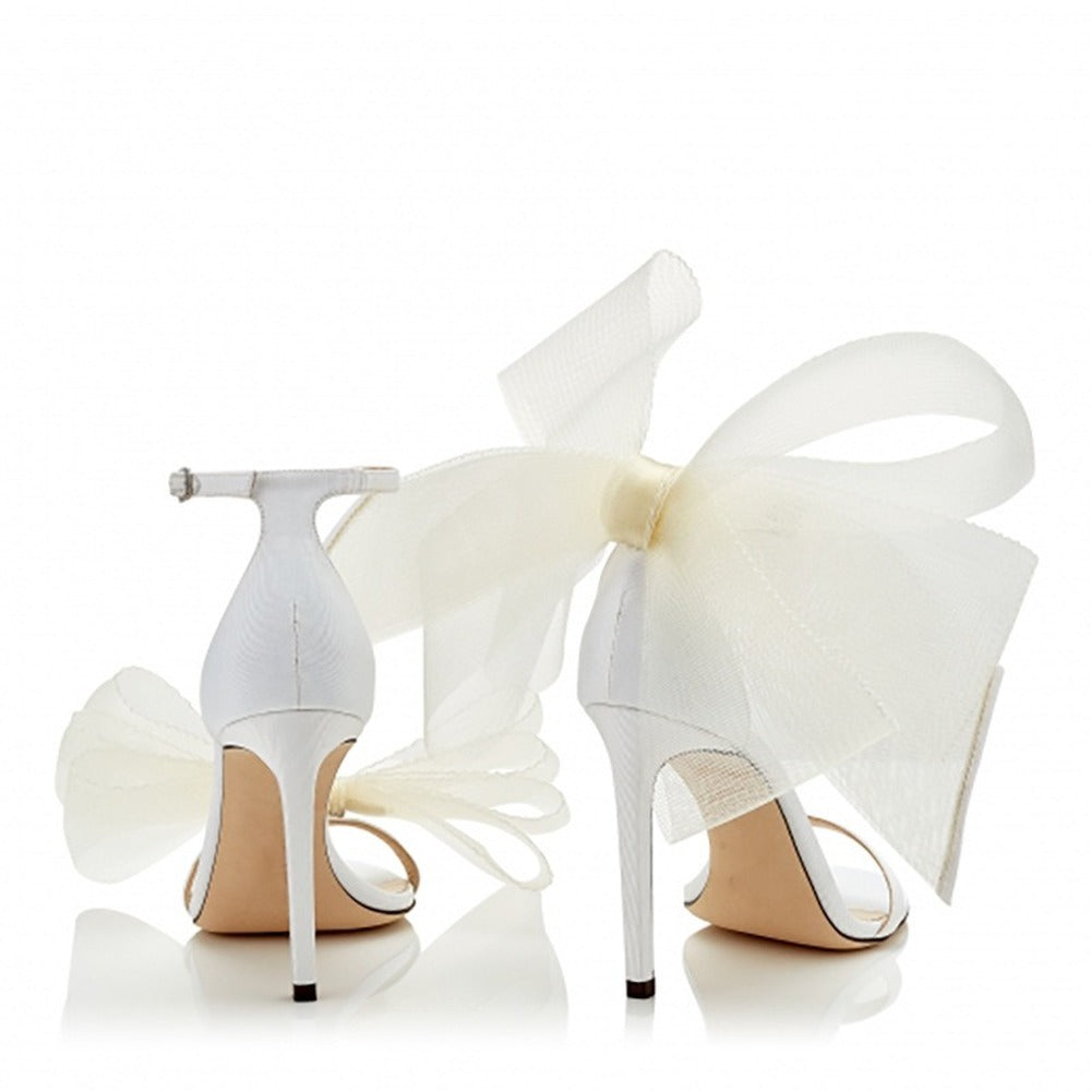 Women's lace up stiletto party sandals in white with large bow detail on the back