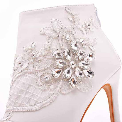 Elegant women's lace wedding boots by Crystal Queen with intricate floral embellishments and crystals