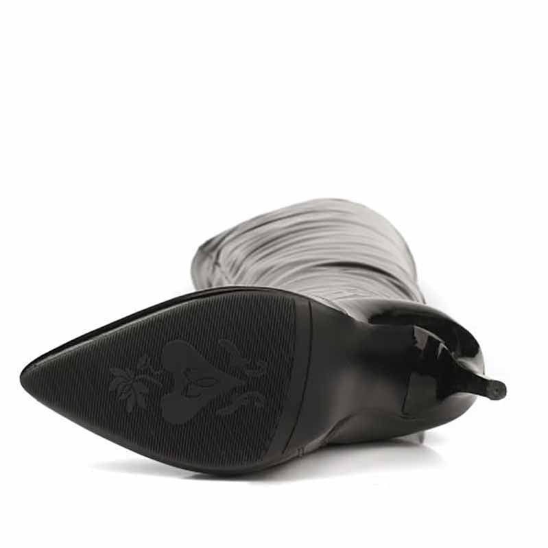 Close-up of women's patent leather thigh high boots showing pointed toe design and textured sole