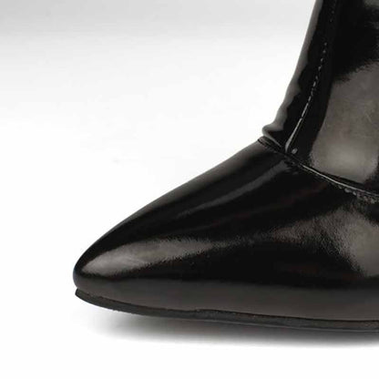 Close-up of women's patent leather thigh high boots with a pointed toe design and glossy finish