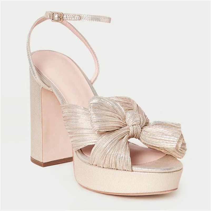 Elegant women's platform bow sandals in gold with a chunky heel, perfect for weddings