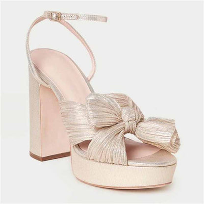 Elegant women's platform bow sandals in gold with a chunky heel, perfect for weddings